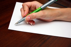 Hand with pen writing a letter