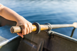 Female Hand On Row Boat Oar Closeup In Summer With Water