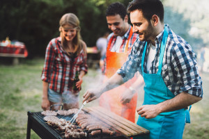 Friends having fun grilling meat enjoying bbq party